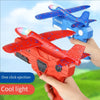 A hand holds an orange foam glider catapult toy gun with a red wing and blue accents, demonstrating one click ejection and co