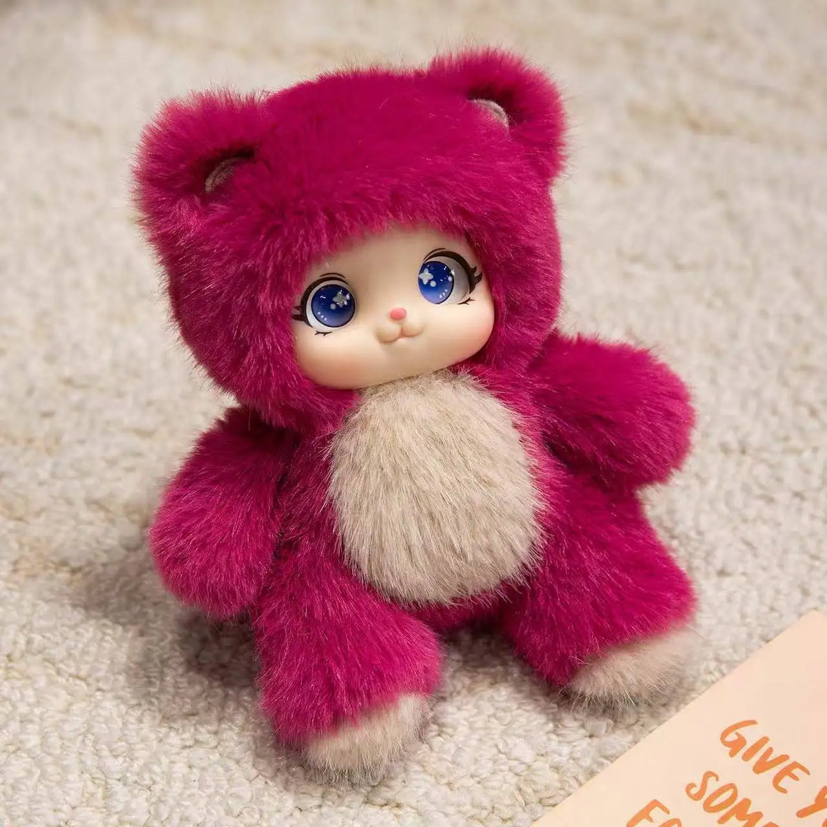 A pink plush pendant featuring a rabbit, bear, and sheep design with soft fur texture.