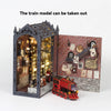 A wooden train model is placed in front of a detailed brick book nook display.