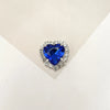 A brilliant blue heart-shaped gemstone surrounded by clear rhinestones.