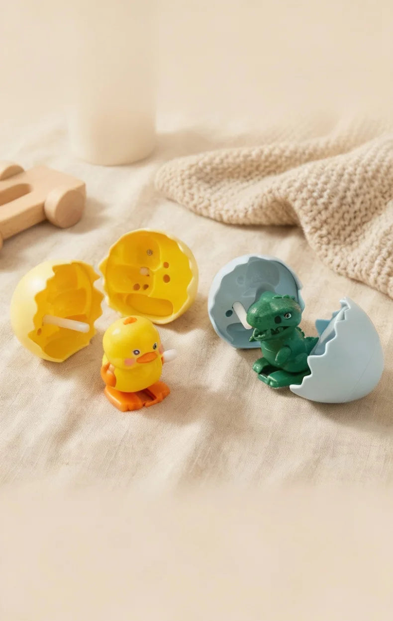 A collection of colorful wind-up bouncing chick toys, including yellow and orange chicks, resting on a beige fabric.