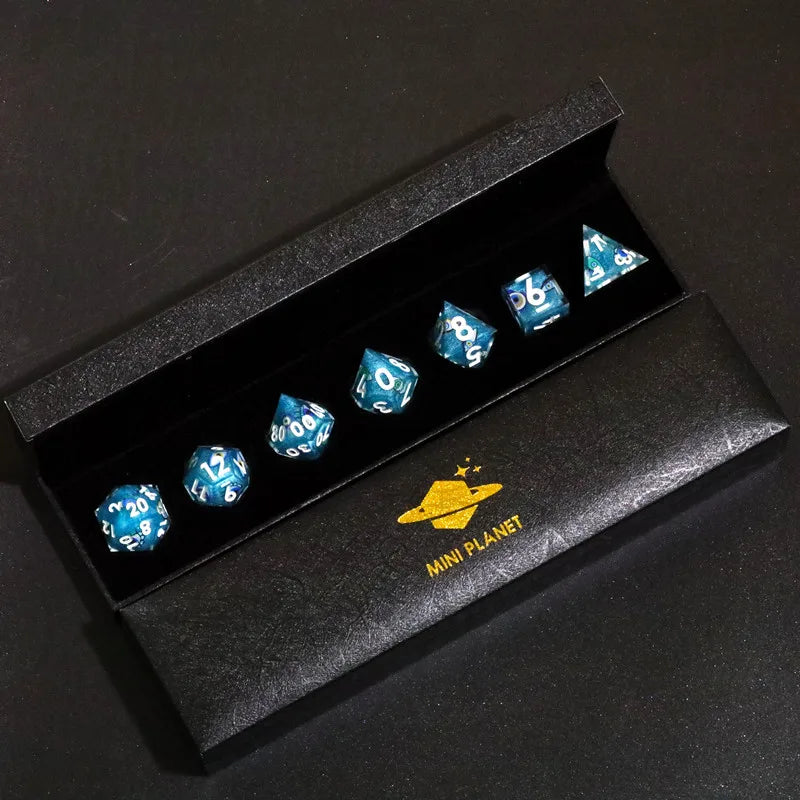 A black box containing a set of mini planet polyhedral dice.