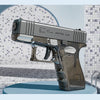 A silver high-power water blaster gun is displayed on a light blue surface against a textured background.