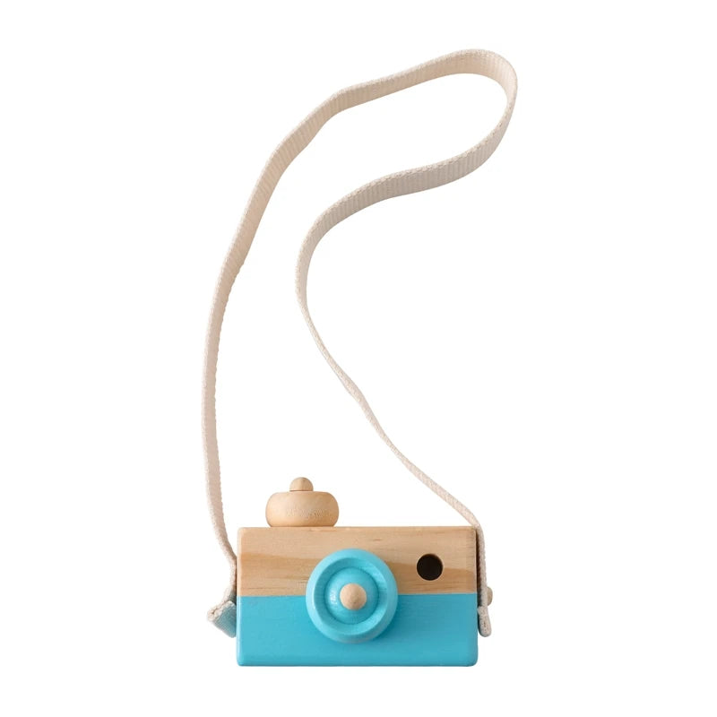 A wooden camera teether toy with a light blue body and a beige strap.