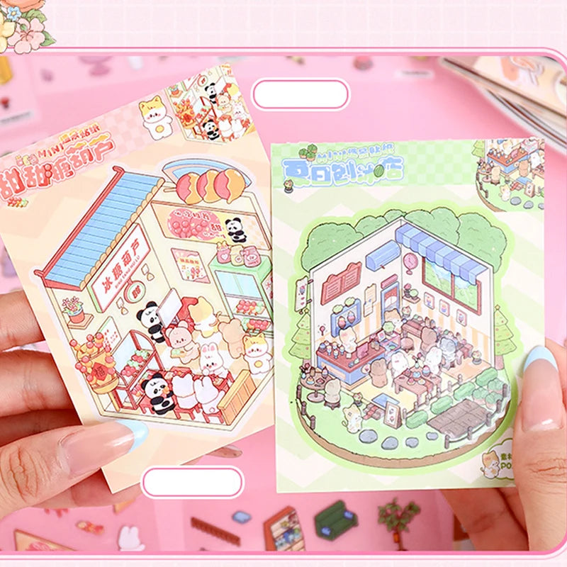 A hand holds an open 21-piece miniature cottage 3D sticker book featuring colorful illustrations for journaling and crafts.