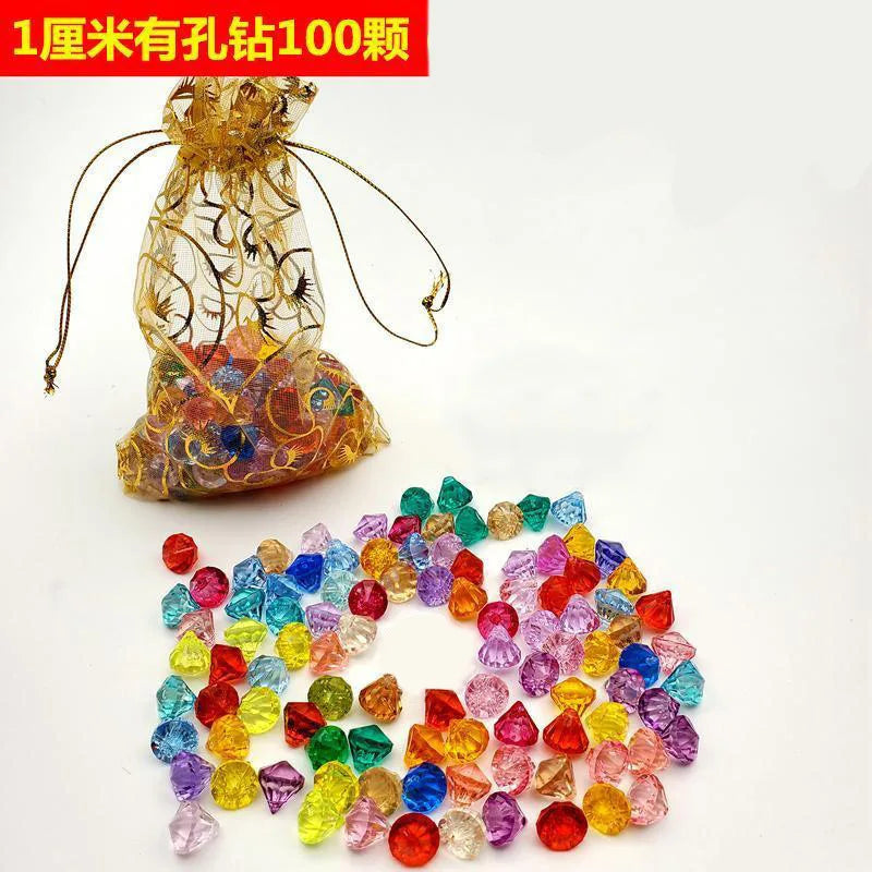 A clear silk bag filled with colorful pirate treasure gemstones and acrylic gems for crafts
