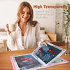 A woman smiles while holding an open transparent diamond painting storage album on a wooden table.