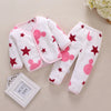 A white fleece jacket and pants set for a baby featuring pink and red cartoon stars and round shapes.