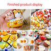 A hand holds a yellow air-dry stone clay animal sculpture with a gold charm and a colorful assortment of food crafts.