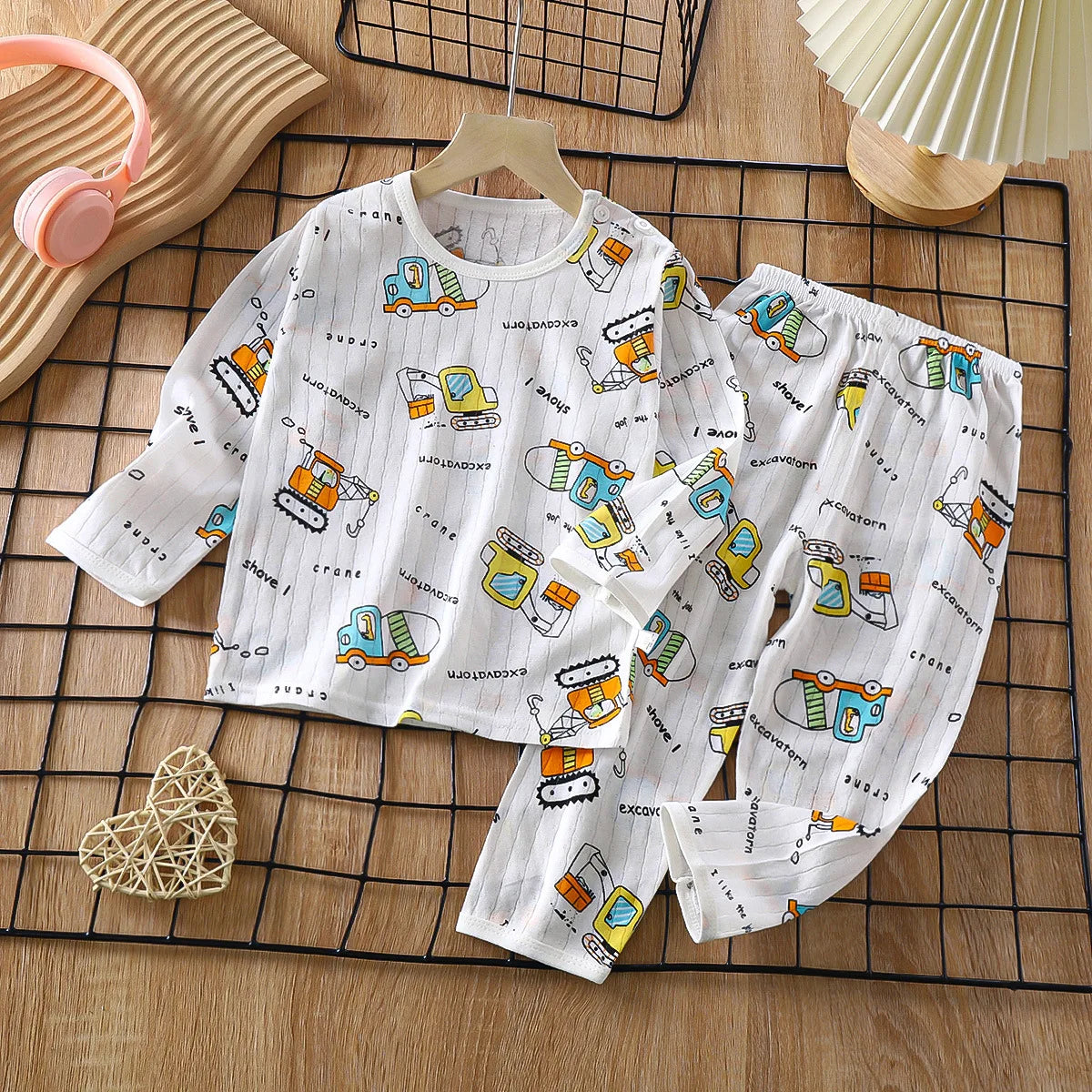 White kids cotton pajama set with a repeating pattern of yellow and blue construction vehicles