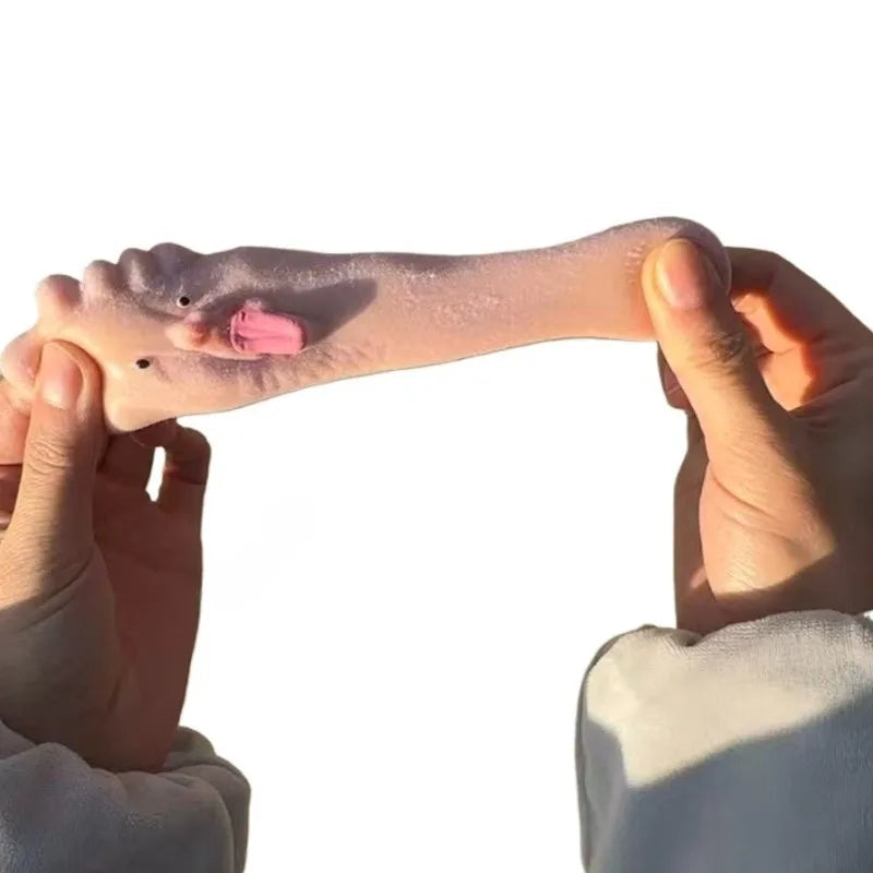 A hand is holding a silicone fidget toy shaped like a tongue sticking out to relieve stress.