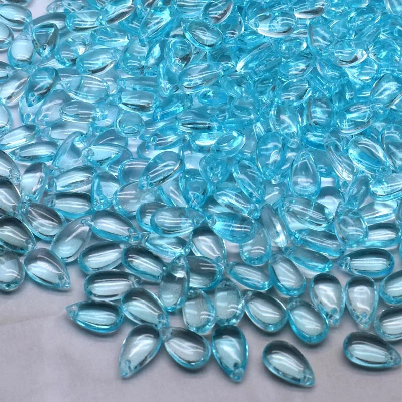 A pile of clear blue water drop Czech glass beads for jewelry making