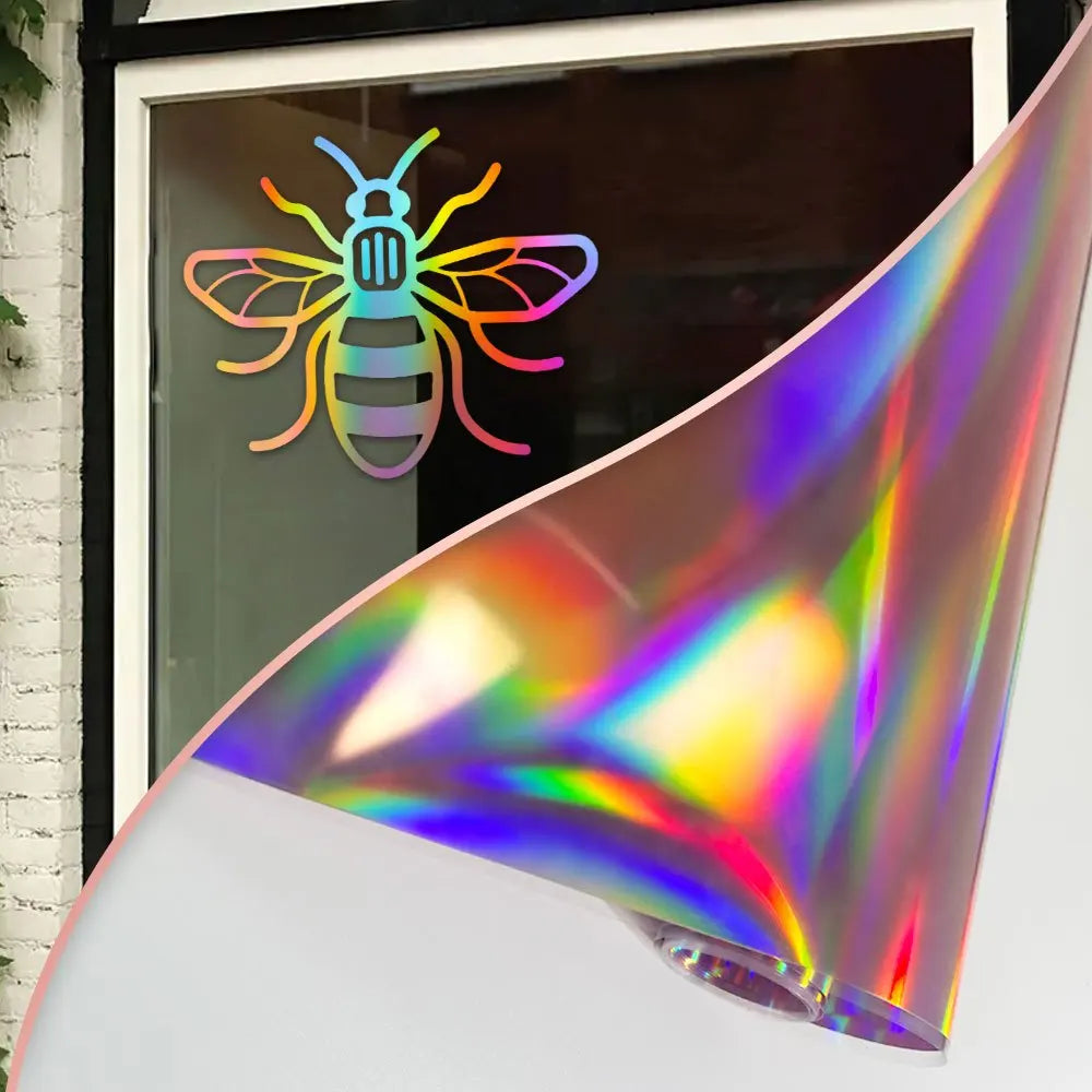 Holographic vinyl roll featuring a colorful bee design displayed against a window.