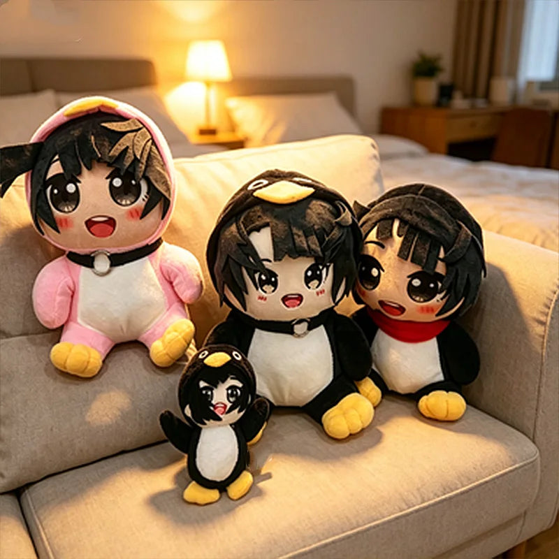 A collection of cute penguin plush toys with black and white features sitting on a light-colored sofa.