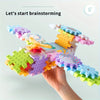 A hand holds a colorful set of motorized gear building blocks and a rail car for brainstorming.