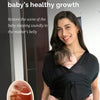 A woman holds a baby in an X-shaped sling carrier while smiling, promoting healthy baby growth.