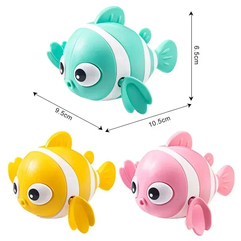 Ein Set aus zwei süßen mechanischen Fischbadspielzeugen, grün und rosa, für Babys.