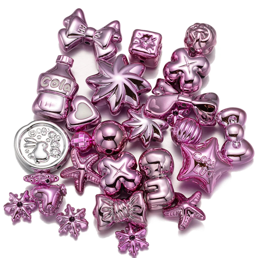 A collection of sparkly pink and purple acrylic bow and flower beads for DIY jewelry making