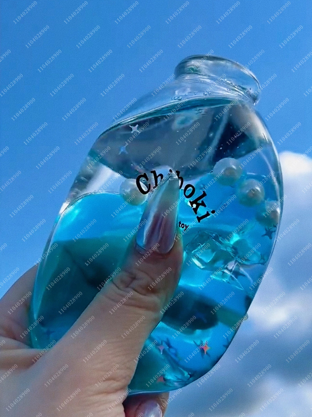 A hand holds a clear glass bottle filled with blue liquid and small bubbles, used as a squishy stress ball.
