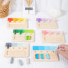 A wooden color matching Montessori toy showing various colored blocks and matching tools on a white surface.