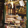A collection of miniature dollhouse components, including wooden pieces, decorative items, and a glass orb, displayed in a ru