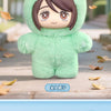 A plush blind box pendant of a green, fuzzy cat character with brown hair standing on a wooden surface.