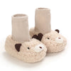 Pair of beige cartoon animal baby booties with knitted cuffs and soft texture.