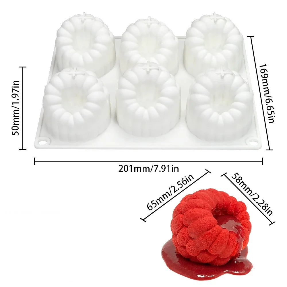 A white silicone mold set with six fruit shapes for baking and desserts, shown next to a piece of red fruit.