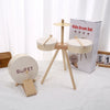 A wooden kids drum set with two drums and a stand is shown next to its packaging box.