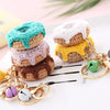 Stack of handmade crochet fruit keychains in pastel colors with gold chain and fruit charms