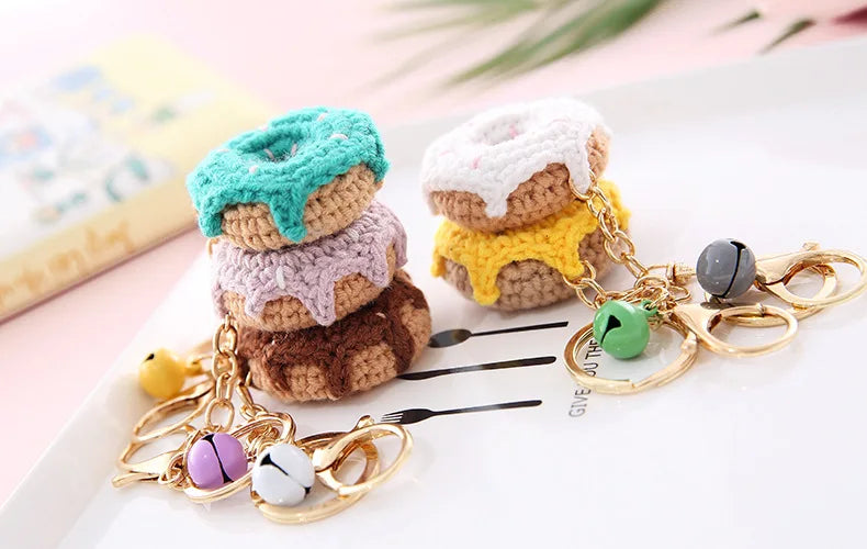 Stack of handmade crochet fruit keychains in pastel colors with gold chain and fruit charms