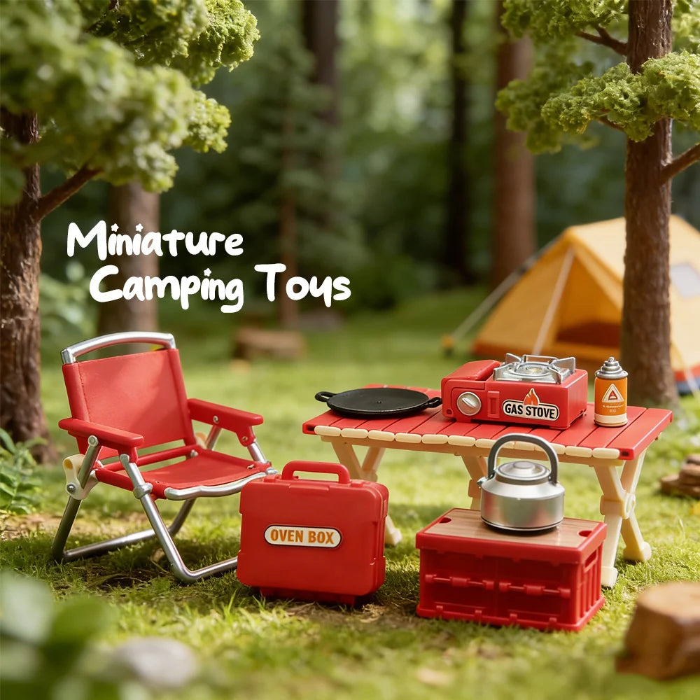 A miniature camping set featuring a red folding chair, gas stove, and oven box displayed in a forest setting.