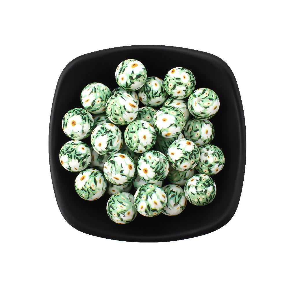 A black bowl filled with small, round, green and white printed silicone beads for jewelry making.