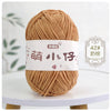 A ball of soft, light brown chenille yarn labeled with Chinese characters for knitting and crochet.