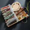 A witchcraft starter kit displayed in a wooden box featuring crystals, herbs, and a decorative mirror.