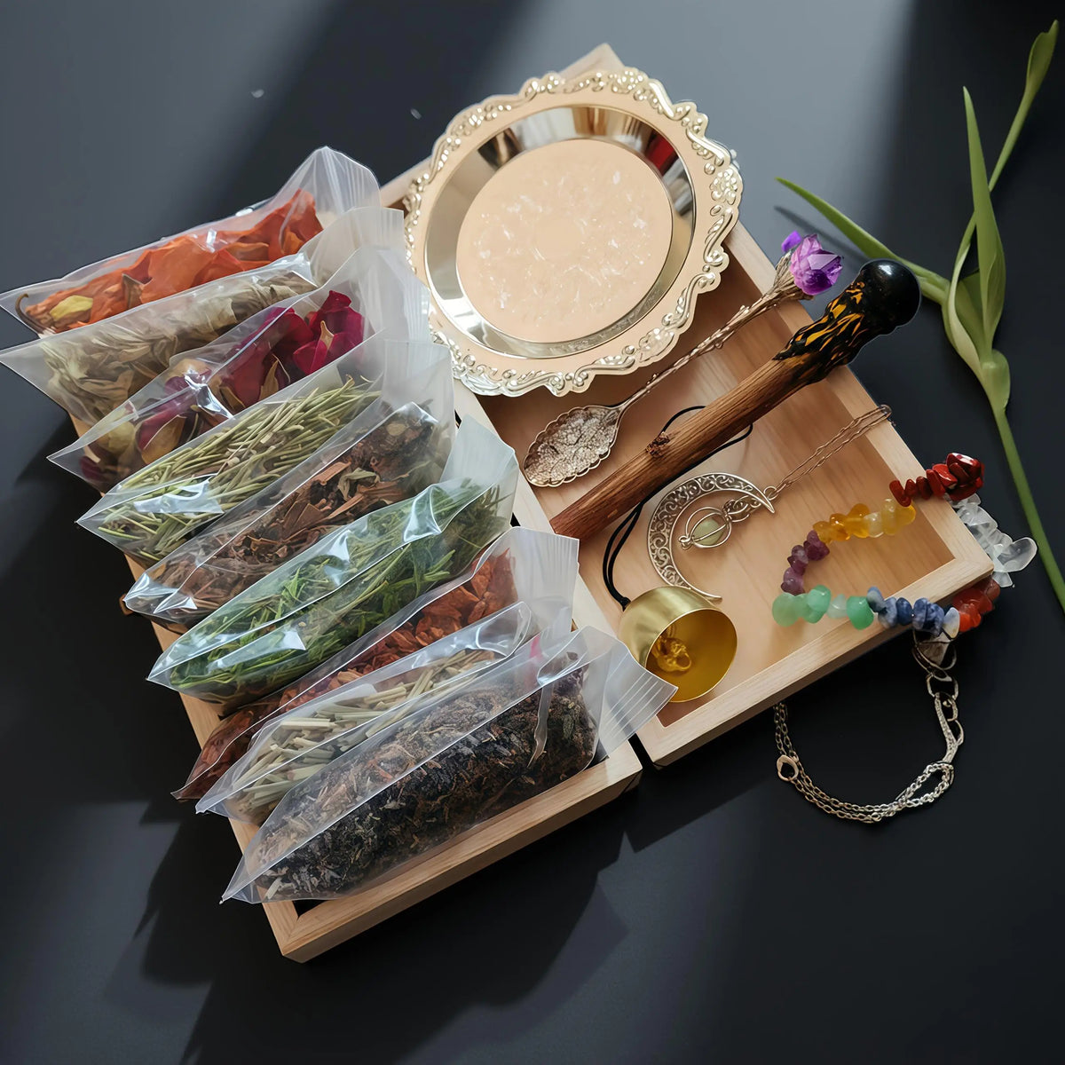A witchcraft starter kit displayed in a wooden box featuring crystals, herbs, and a decorative mirror.