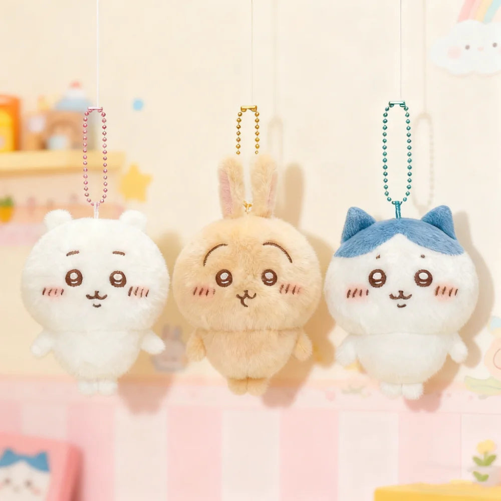 Three soft, fluffy Chiikawa Usagi plush keychains hanging by strings against a light background.