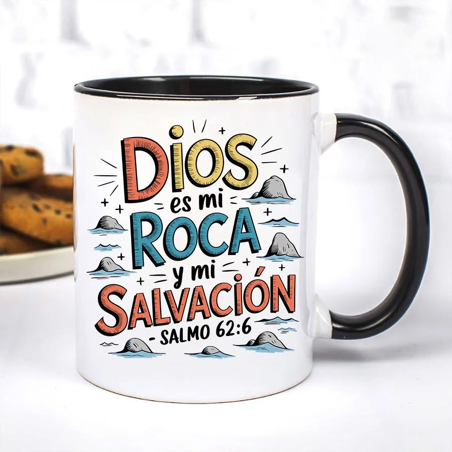 A white ceramic mug with a colorful Spanish Bible verse printed on it, featuring the text Dios es mi Roca y mi Salvación Salm
