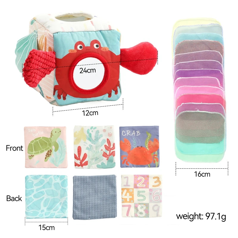 A soft fabric tissue box sensory toy featuring a crab design with various colored fabric inserts and number cards.