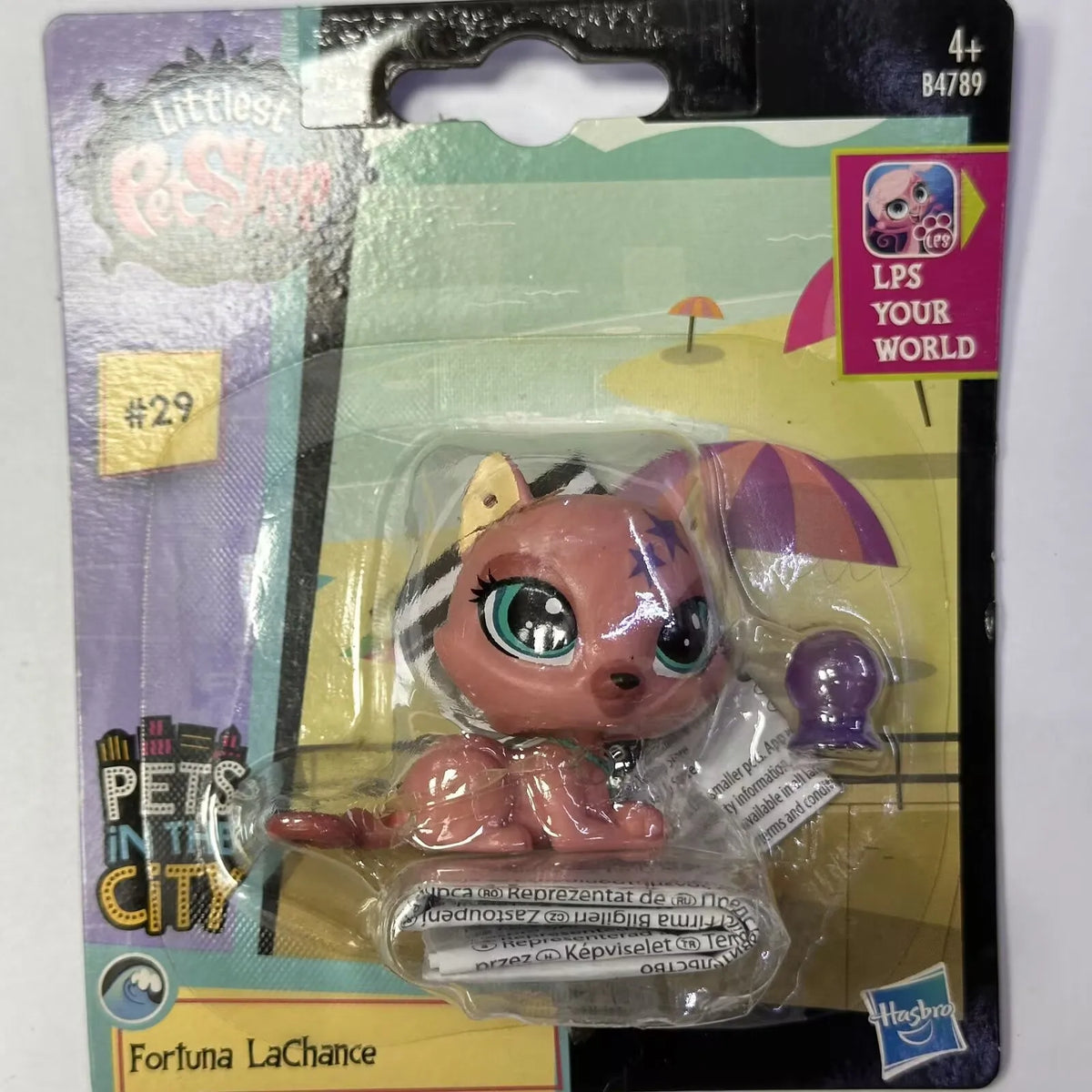 A packaged figure of Fortuna LaChance, a small animal character with pink and purple features.