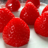 Close-up of bright red strawberry squishy fidget toys resting on a white plate.