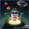 A collectible figurine of a crying baby astronaut with large glasses and a pink outfit floating above a dark space background