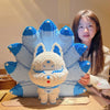A woman holds a large, detailed building block model of a nine-tailed fox in light blue and white.