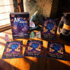 A collection of Akashic Records Oracle Cards and a box featuring the title AK ASHIC on a wooden surface.