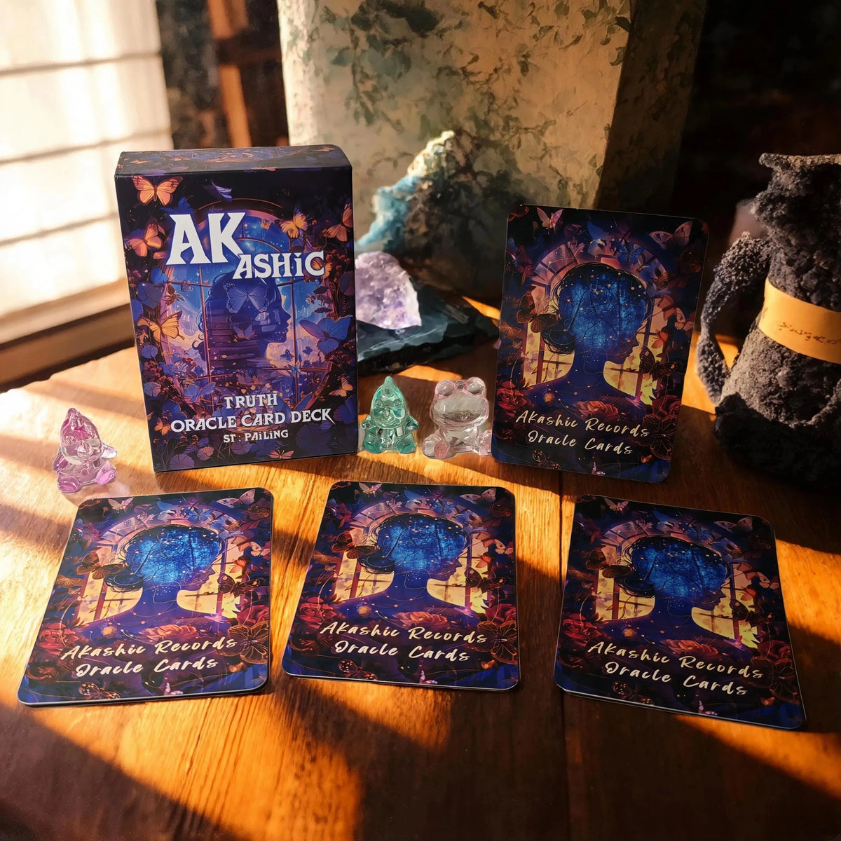 A collection of Akashic Records Oracle Cards and a box featuring the title AK ASHIC on a wooden surface.