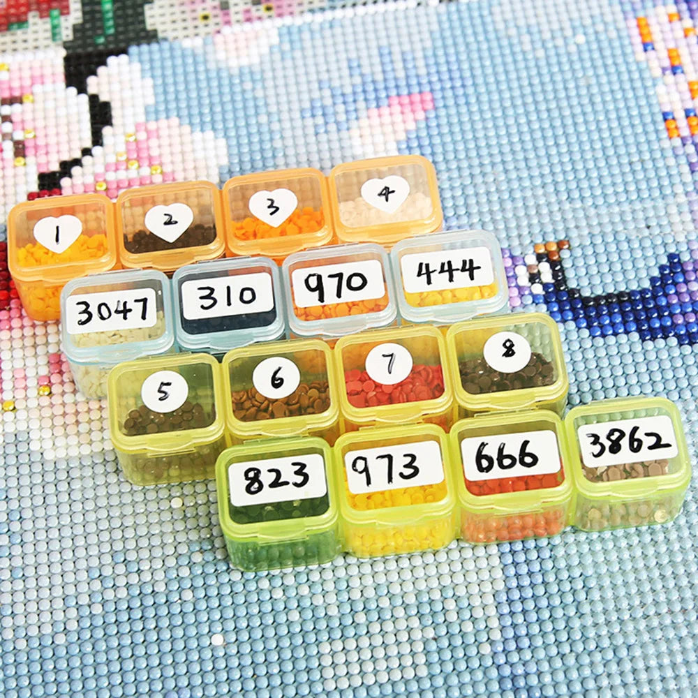 A collection of diamond painting beads organized in numbered plastic storage trays on a light blue background.
