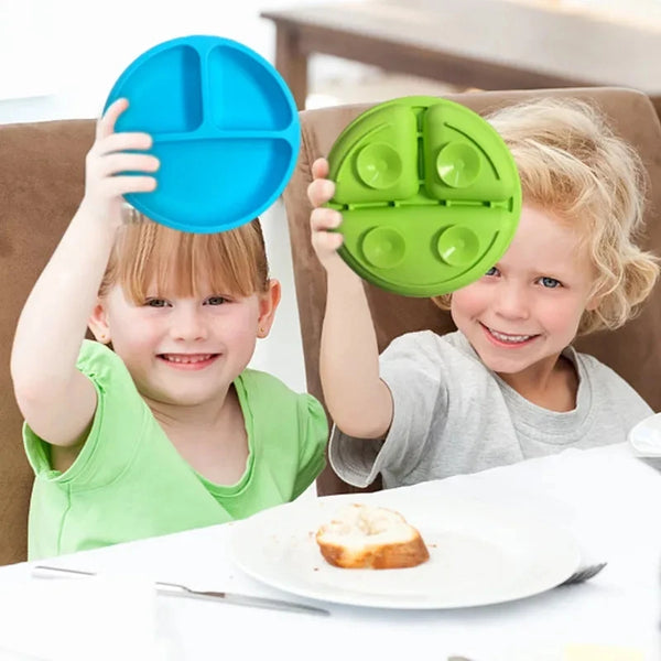 Deux tout-petits tiennent des disques de tétine en silicone bleu vif et vert sur une assiette blanche.