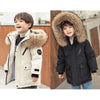 A young boy models a beige hooded winter jacket with a large brown fur collar.