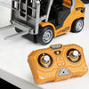 A yellow and black mini RC forklift truck model with a metal fork and an orange remote control transmitter.
