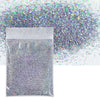 A clear bag filled with holographic fine glitter powder next to a loose pile of iridescent glitter.